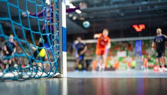 Handball goal with net and handball match in the background