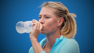 Maria Sharapova drinking water on tennis court