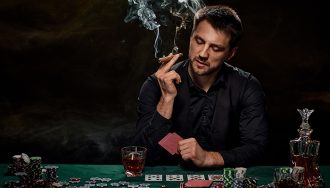 A man playing poker while friends sitting on table in casino