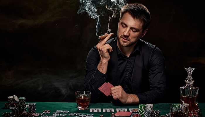 A man playing poker while friends sitting on table in casino