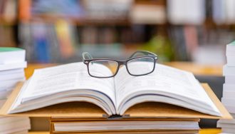 A pair of glasses on top of books