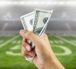 Sports betting concept represented by US dollars, the word betting, and a phone