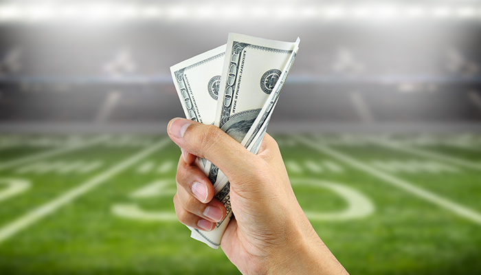 Sports betting concept represented by US dollars, the word betting, and a phone