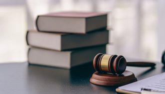 A judge's gavel on top of a stack of documents